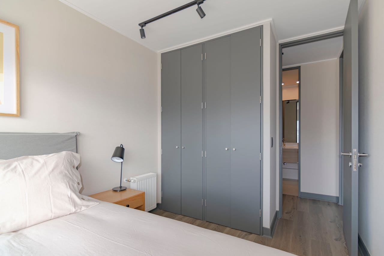 Home Contemporary bedroom featuring grey wardrobe and minimal decor, ideal for urban apartments.